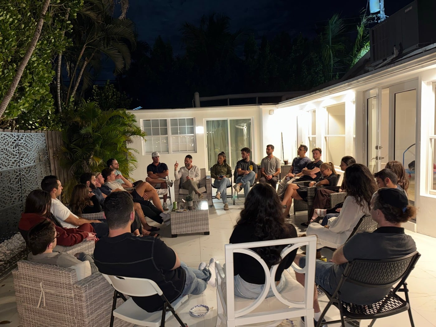 A tribe class on the patio at night, everyone in a circle